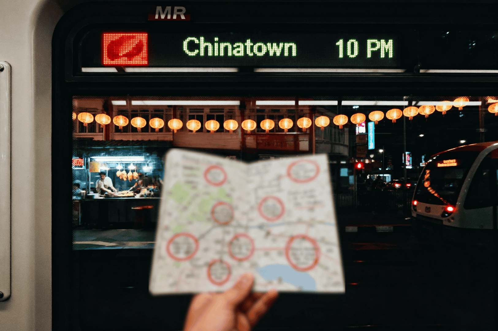 After-MRT- (2) Inside an MRT car bound for Chinatown at 10 PM, a traveler holds a map marked with red circles, while lantern-lit streets and food stalls glow outside the window—capturing the anticipation of a midnight food photographer’s urban adventure.