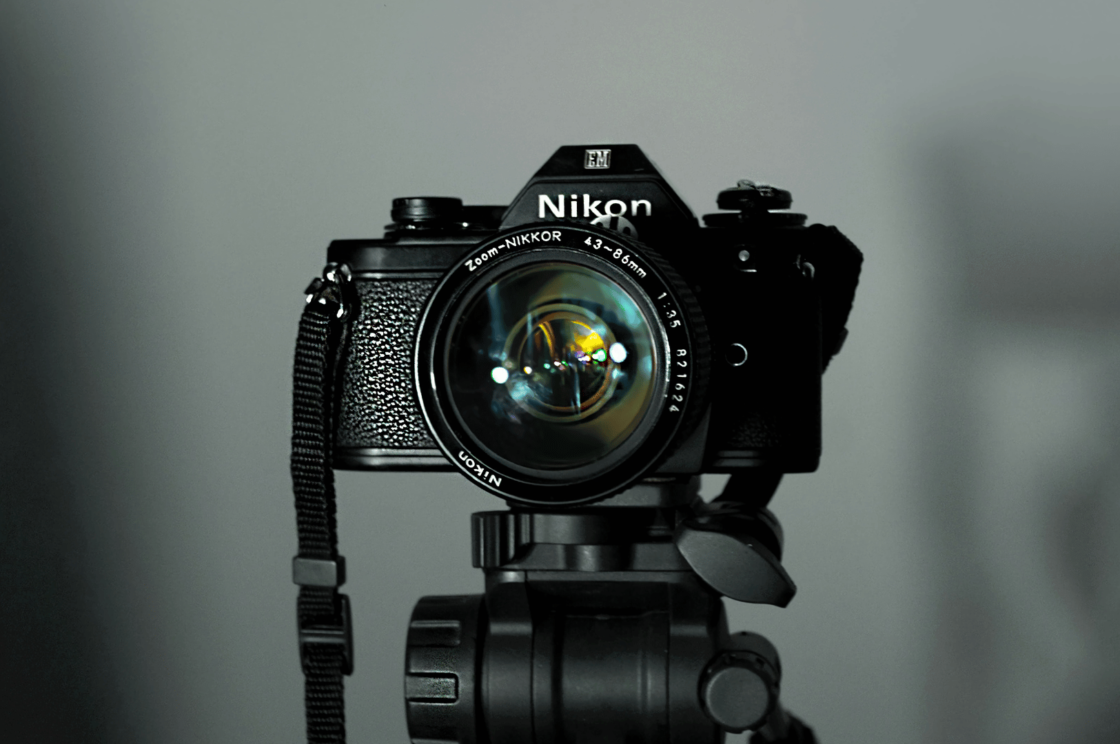 Night-And-Day- (1) Vintage Nikon film camera mounted on a tripod, spotlighted against a neutral gray backdrop—evoking the timeless precision behind both low-light and daylight food photography. The attached NIKKOR 50mm f/1.4 lens hints at cinematic depth and shallow focus, bridging analog artistry with modern visual storytelling.