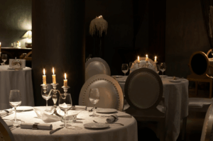 Elegant fine-dining restaurant with candlelit tables, white linens, and ornate candelabras, evoking Singapore’s rich culinary heritage and intimate Michelin-worthy ambiance.