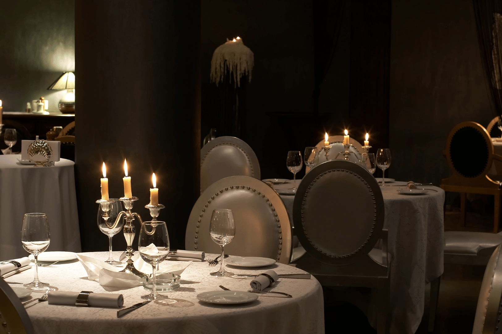 Michelin-Guide-SG- (1) Elegant fine-dining restaurant with candlelit tables, white linens, and ornate candelabras, evoking Singapore’s rich culinary heritage and intimate Michelin-worthy ambiance.