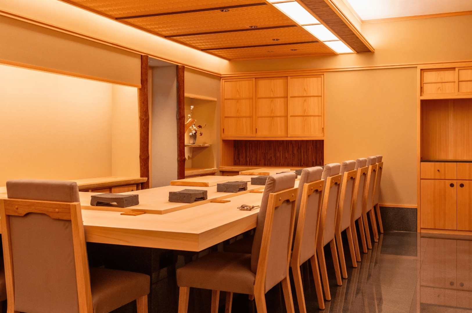 Michelin-Guide-SG- (3) Serene Japanese dining room at Sushi Sakuta in Singapore, featuring warm wood tones, minimalist elegance, and refined table settings that reflect the Michelin Guide’s celebration of culinary artistry and cultural memory.