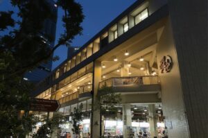 Exterior night view of the multi-story Amoy Street Food Centre in Singapore, featuring its distinct stepped-terrace architecture and illuminated open-air dining decks.