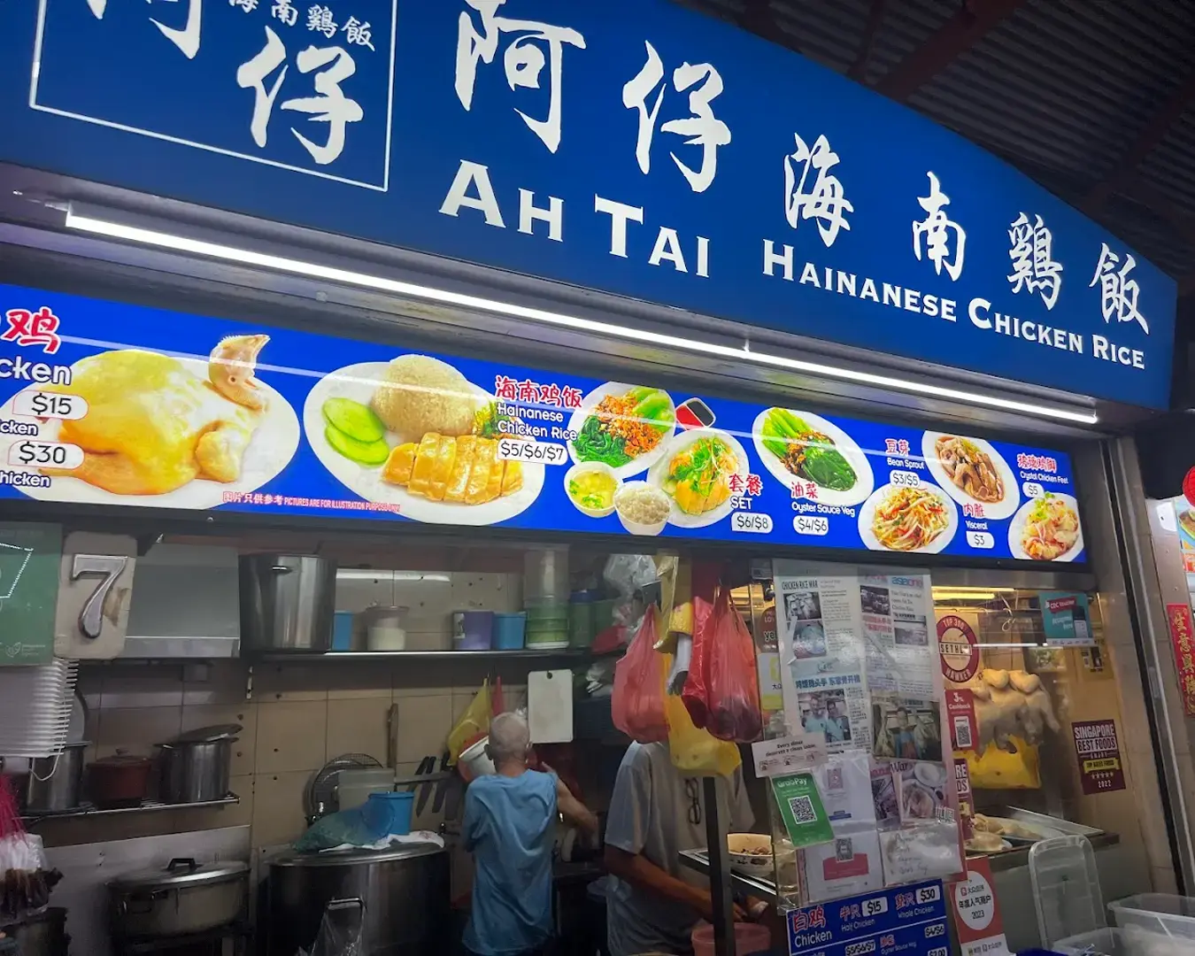 A shop of Hainanese chicken rice,Tian Tian, featuring tender poached chicken slices served with fragrant rice, accompanied by chilli sauce and ginger paste.