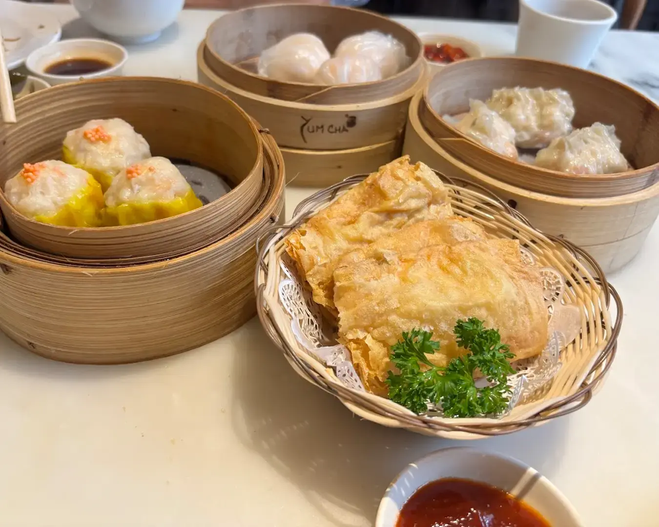 A vibrant spread of bite-sized dumplings and small dishes arranged neatly on plates, showcasing different colours, fillings, and textures in a dim sum–style presentation