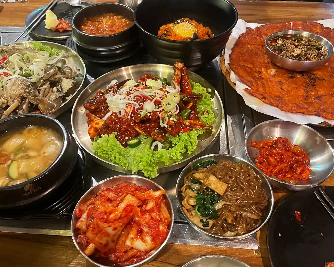 A Korean food spot featuring a close view of vibrant kimchi served in a small dish, with its rich red colour and textured layers of cabbage highlighting its bold, fermented flavours.