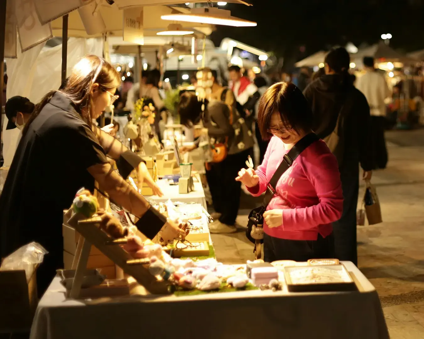 A street vendor speak to a customer across a small stall counter, capturing a candid moment of exchange and everyday interaction in a local market setting.
