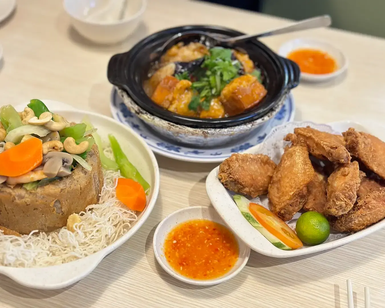 A dining table at Kok Sen Restaurant filled with a variety of Chinese dishes, including stir-fried vegetables, and savoury mains, ready to be shared family-style.