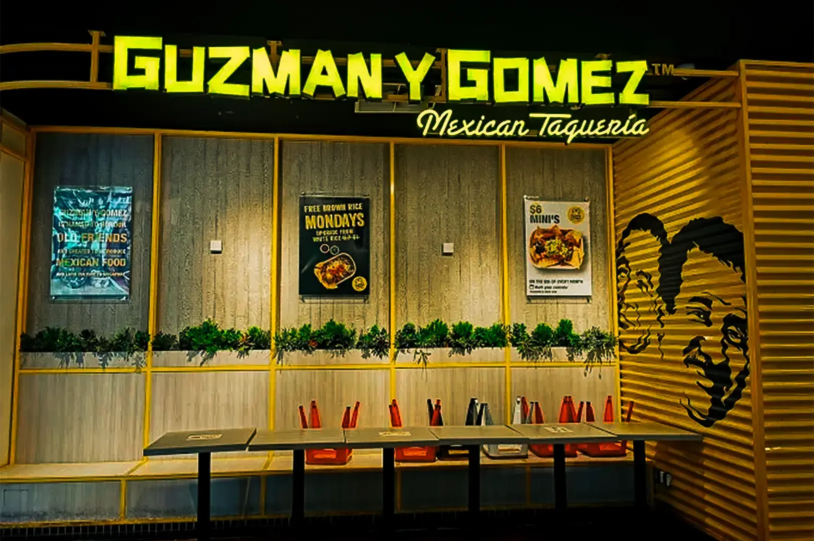 Guzman y Gomez storefront at Orchard Gateway near Somerset MRT Station, with its illuminated sign and counter visible inside.
