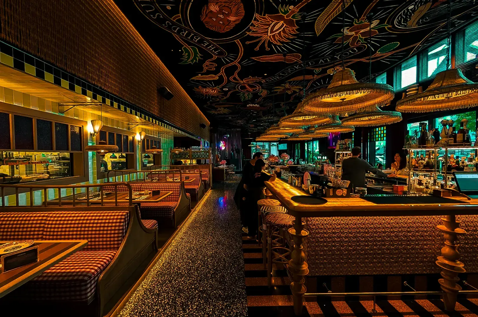 Interior of Mama Restaurant on Killiney Road, featuring patterned décor, upholstered seating and neon lighting.
