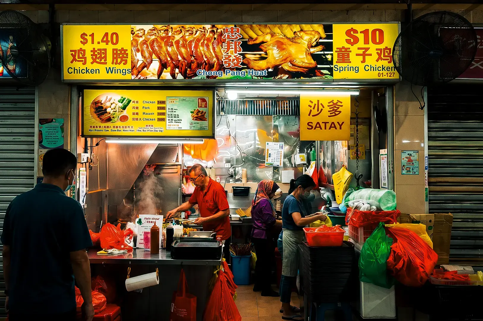 Chong Pang Huat stall exterior with its yellow and red menu signage above and busy staff cooking meals inside located at Newton Food Centre.