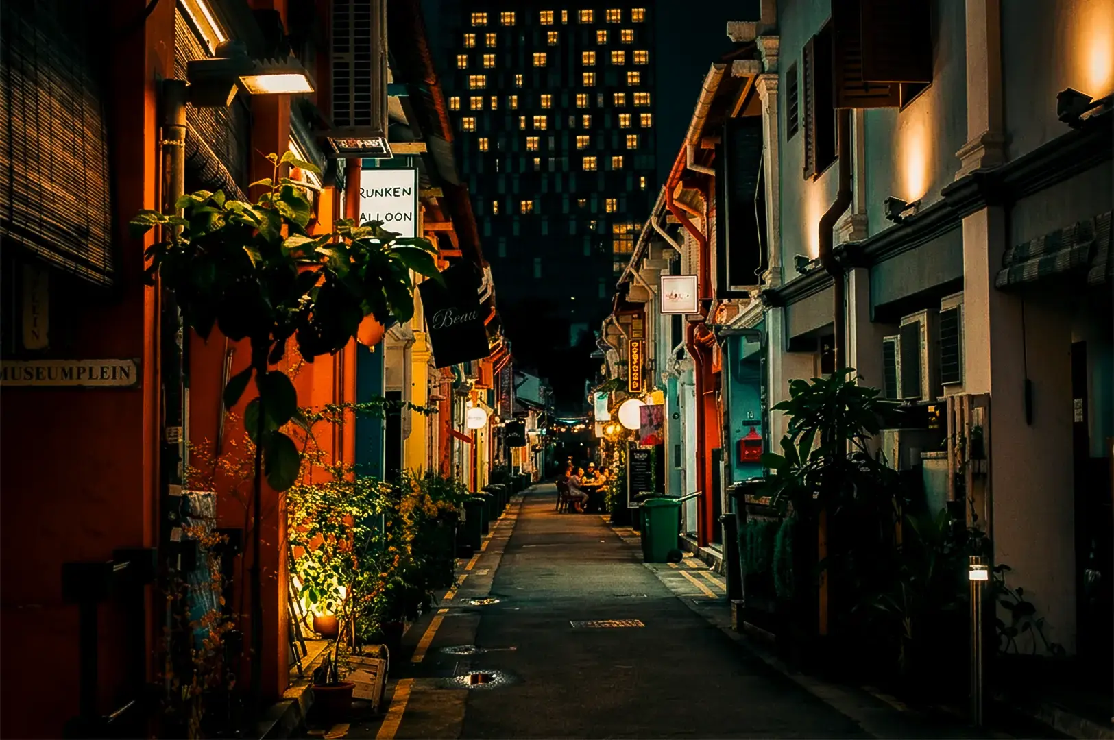Wide street view shot of Haji Lane, Singapore at night with colorful buildings on either side.