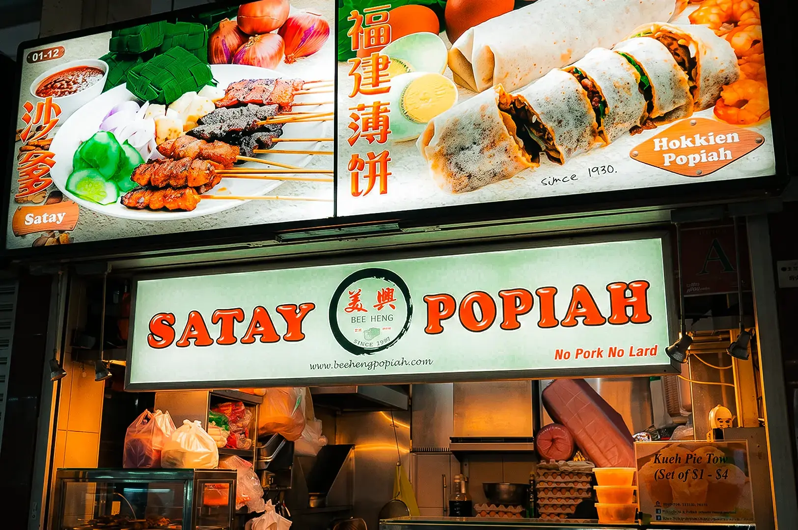 Bee Heng Popiah exterior with menu items and logo signage hanging in front of the stall at Newton Food Centre.