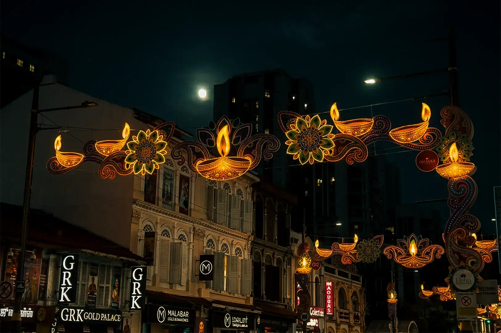 Low angle shot of Little India Arcade in Singapore at night with a distinct Indian pattern sign illuminating the streets.