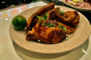 Grilled BBQ Chicken with lime on a white plate served at Chong Pang Huat.