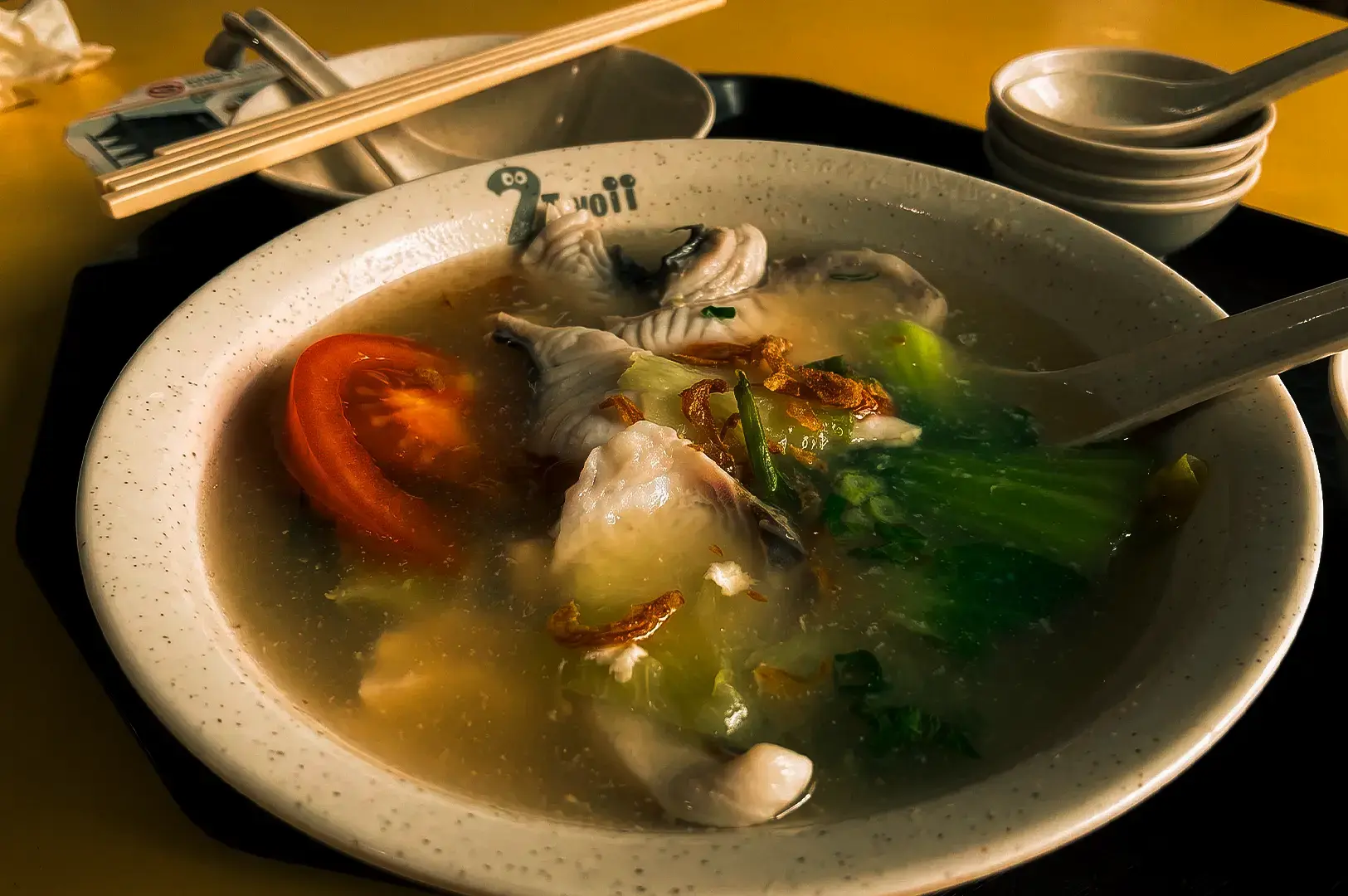 A serving of dish soup at Hock Heng Fish Soup in a white bowl on a black tray.